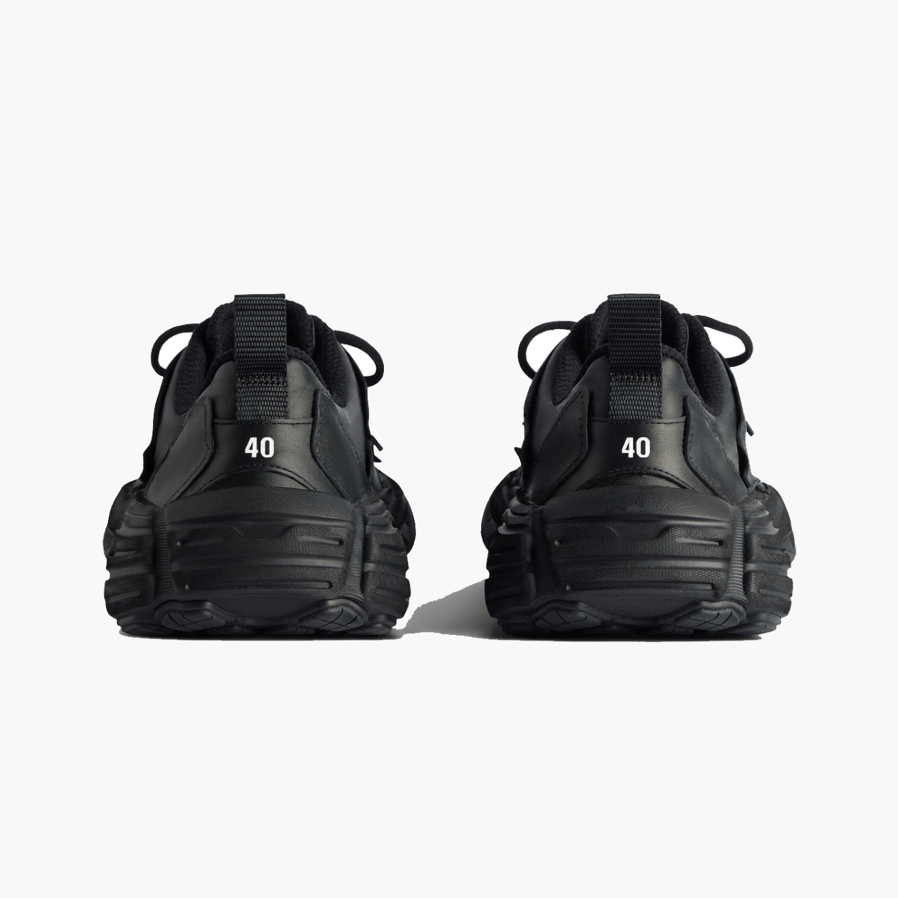 Vue arrière des sneakers Balenciaga Monday Shoe en cuir noir, talons marqués du logo, paire présentée chez Lesthete Concept Store.